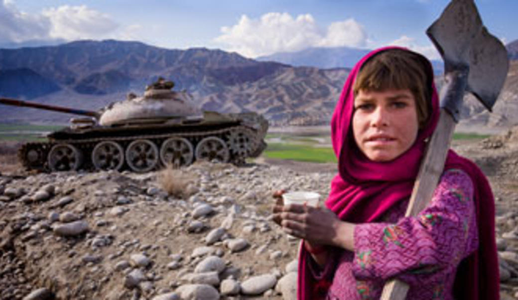 Girl in mountainous terrain near tank